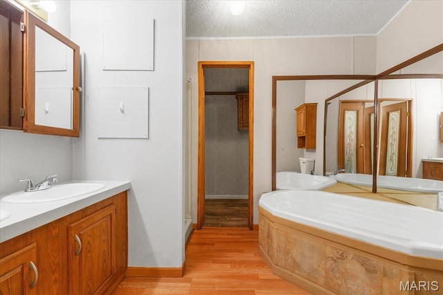 434 Cool Springs Ln, Wright City, MO 63390 - full bathroom featuring vanity, wood finished floors, a stall shower, a garden tub, and a textured ceiling