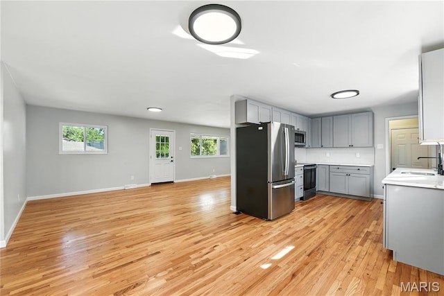 100 Toelle Dr, Saint Charles, MO 63304 - kitchen with appliances with stainless steel finishes, gray cabinets, light wood-style flooring, and plenty of natural light