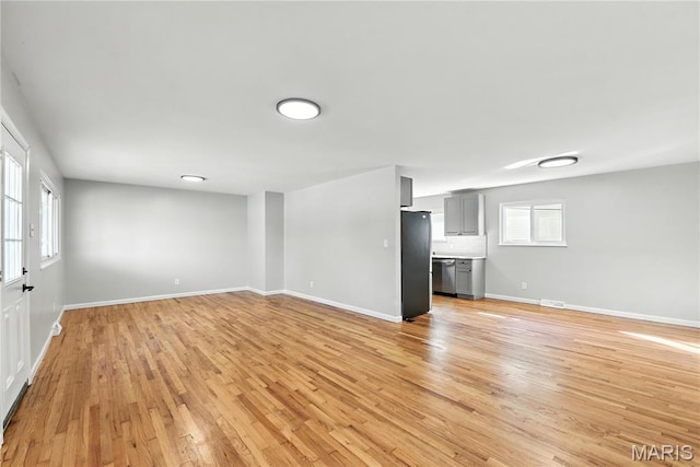 100 Toelle Dr, Saint Charles, MO 63304 - unfurnished living room featuring light wood-style flooring and baseboards
