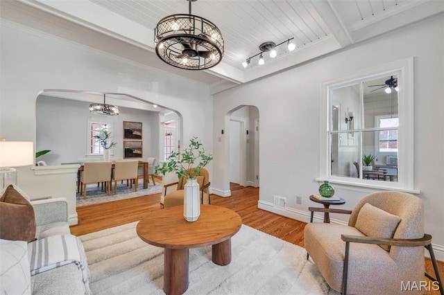 2733 Hermitage Ave, Saint Louis, MO 63143 - living area featuring arched walkways, a chandelier, wood finished floors, and a wood ceiling with exposed beams
