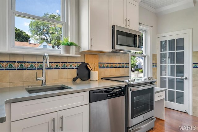 2733 Hermitage Ave, Saint Louis, MO 63143 - kitchen with appliances with stainless steel finishes, white cabinets, and healthy amount of natural light