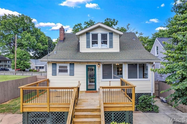 2733 Hermitage Ave, Saint Louis, MO 63143 - view of front facade with a wooden deck, a fenced backyard, a shingled roof, and a chimney