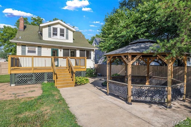 2733 Hermitage Ave, Saint Louis, MO 63143 - back of house with a fenced backyard, a gazebo, a chimney, a deck, and a patio