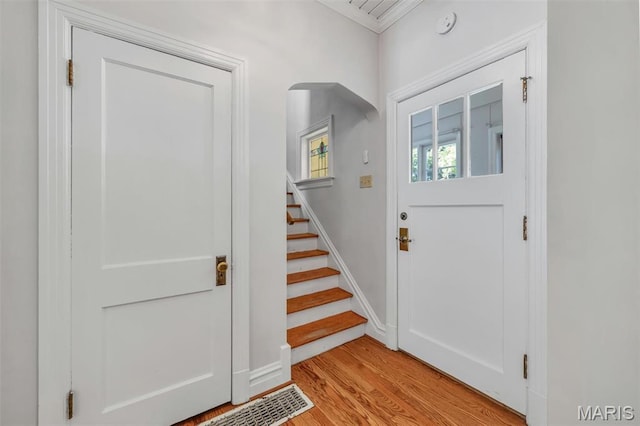 2733 Hermitage Ave, Saint Louis, MO 63143 - foyer entrance featuring stairs, light wood-style flooring, and ornamental molding