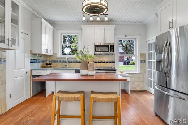 2733 Hermitage Ave, Saint Louis, MO 63143 - kitchen with stainless steel appliances, butcher block counters, white cabinetry, light wood-type flooring, and wooden ceiling