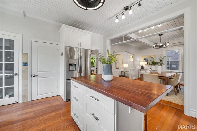 2733 Hermitage Ave, Saint Louis, MO 63143 - kitchen with stainless steel fridge with ice dispenser, wood counters, light wood finished floors, arched walkways, and white cabinets