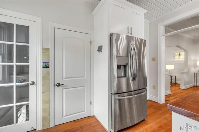 2733 Hermitage Ave, Saint Louis, MO 63143 - kitchen with stainless steel fridge, light wood finished floors, white cabinets, dark countertops, and wooden ceiling