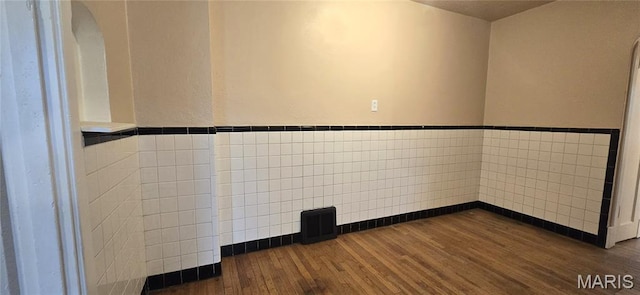6128 Bircher St, Saint Louis, MO 63120 - spare room with dark wood-type flooring, tile walls, wainscoting, and arched walkways