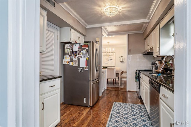 107 Huntleigh Dr, Kirkwood, MO 63122 - kitchen with appliances with stainless steel finishes, dark countertops, a chandelier, dark wood finished floors, and under cabinet range hood