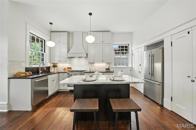 6336 Pershing Ave, University City, MO 63130 - kitchen featuring custom range hood, high end appliances, dark wood finished floors, and a center island