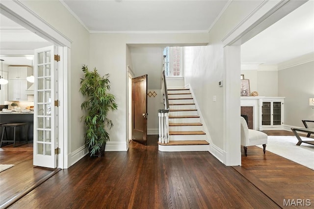 6336 Pershing Ave, University City, MO 63130 - stairway featuring wood-type flooring, a brick fireplace, ornamental molding, and french doors