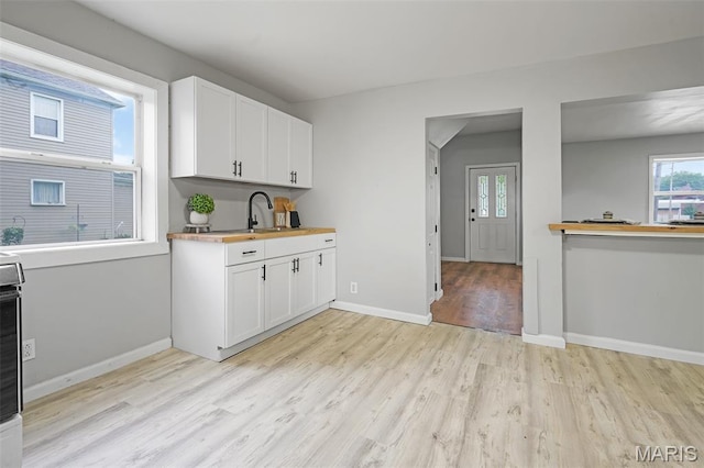 2162 State St, Granite City, IL 62040 - kitchen with light wood-style floors, white cabinetry, stove, and butcher block counters