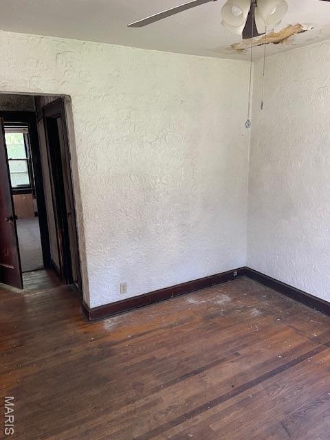 8614 Hume Ave, St John, MO 63114 - empty room with a textured wall, dark wood-type flooring, and ceiling fan