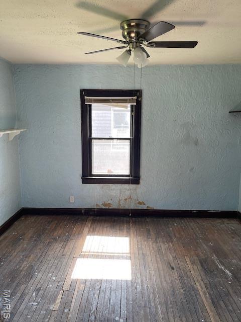 8614 Hume Ave, St John, MO 63114 - unfurnished room featuring hardwood / wood-style flooring, ceiling fan, and a textured wall