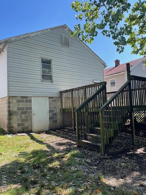 8614 Hume Ave, St John, MO 63114 - back of property featuring a wooden deck and stairway