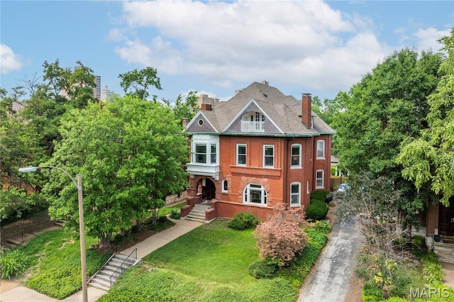 4365 Forest Park Ave, Saint Louis, MO 63108 - view of front of property featuring a chimney, a front lawn, and asphalt driveway
