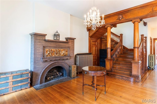 4365 Forest Park Ave, Saint Louis, MO 63108 - living room with wood finished floors, a chandelier, stairs, and radiator