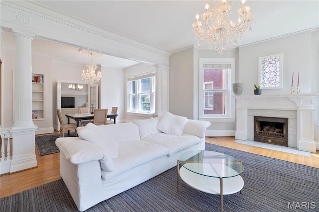 4365 Forest Park Ave, Saint Louis, MO 63108 - living room with a chandelier, wood finished floors, crown molding, a fireplace with flush hearth, and built in shelves