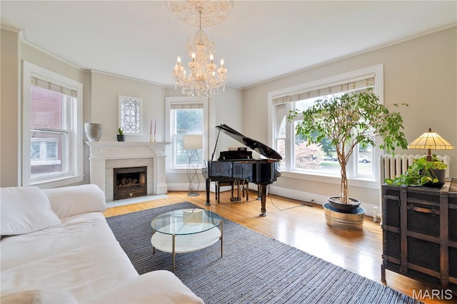 4365 Forest Park Ave, Saint Louis, MO 63108 - living room featuring ornamental molding, wood finished floors, a chandelier, and a fireplace with flush hearth