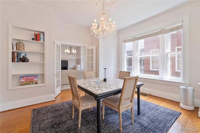 4365 Forest Park Ave, Saint Louis, MO 63108 - dining room with a chandelier, light wood-style flooring, crown molding, and built in features