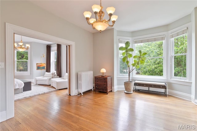 4365 Forest Park Ave, Saint Louis, MO 63108 - unfurnished room featuring radiator, a chandelier, and wood finished floors
