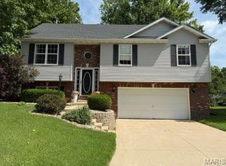 14 Shaderest Ct, Glen Carbon, IL 62034 - raised ranch with brick siding, concrete driveway, a garage, and a front yard