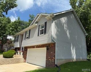 14 Shaderest Ct, Glen Carbon, IL 62034 - view of property exterior featuring an attached garage, driveway, and brick siding