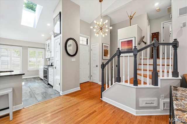 1909 King Arthur Ct, Saint Louis, MO 63146 - entrance foyer with stairway, a skylight, light wood-type flooring, a chandelier, and high vaulted ceiling