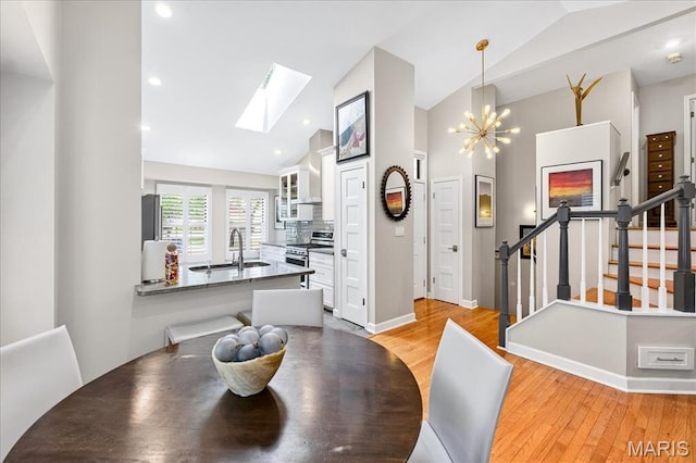 1909 King Arthur Ct, Saint Louis, MO 63146 - dining room featuring a skylight, light wood finished floors, stairway, high vaulted ceiling, and a chandelier