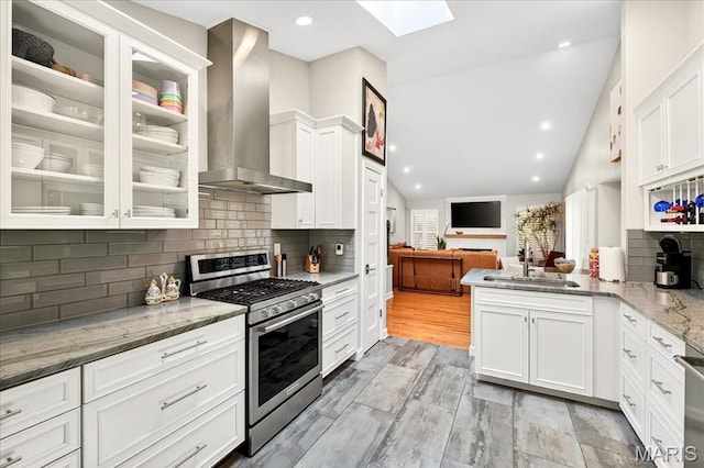 1909 King Arthur Ct, Saint Louis, MO 63146 - kitchen featuring stainless steel appliances, wall chimney exhaust hood, a skylight, open floor plan, and white cabinetry