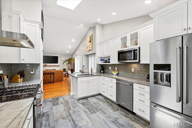 1909 King Arthur Ct, Saint Louis, MO 63146 - kitchen with stainless steel appliances, wall chimney exhaust hood, a peninsula, white cabinets, and recessed lighting