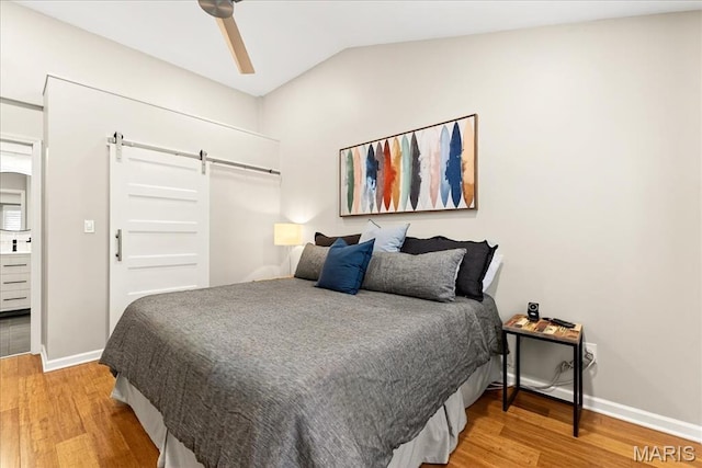 1909 King Arthur Ct, Saint Louis, MO 63146 - bedroom featuring a barn door, light wood-style floors, vaulted ceiling, and ceiling fan