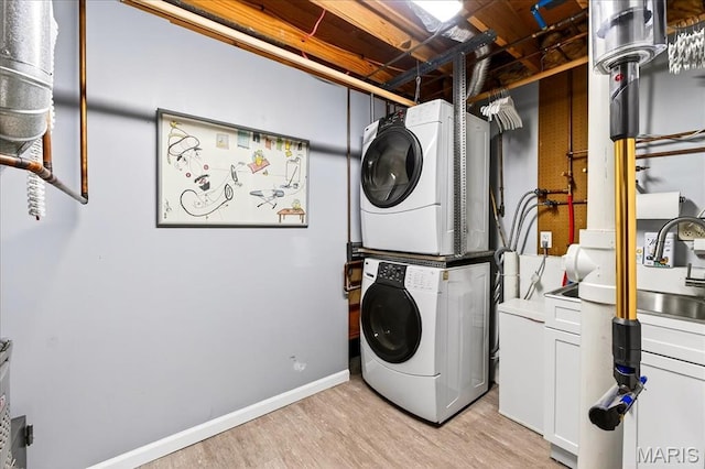 1909 King Arthur Ct, Saint Louis, MO 63146 - laundry area with stacked washing machine and dryer, cabinet space, and light wood-type flooring