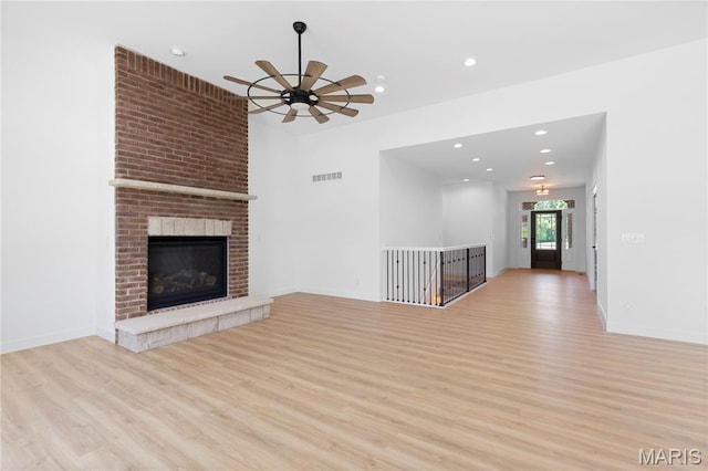522 Dove Dr, Saint Charles, MO 63301 - unfurnished living room featuring light wood-style floors, a ceiling fan, recessed lighting, and a brick fireplace
