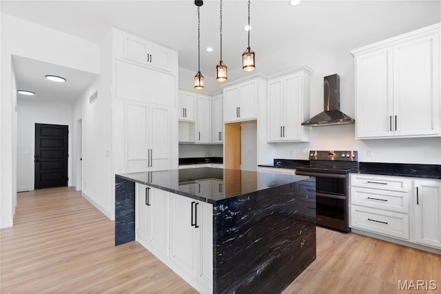522 Dove Dr, Saint Charles, MO 63301 - kitchen with wall chimney range hood, black / electric stove, light wood finished floors, dark stone countertops, and recessed lighting