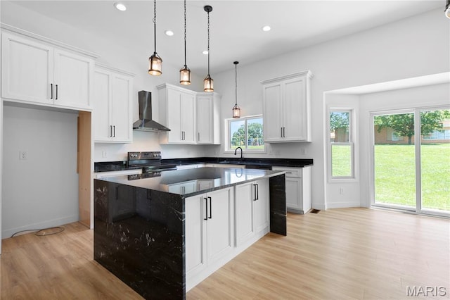 522 Dove Dr, Saint Charles, MO 63301 - kitchen with wall chimney exhaust hood, black range with electric cooktop, recessed lighting, light wood-type flooring, and white cabinetry