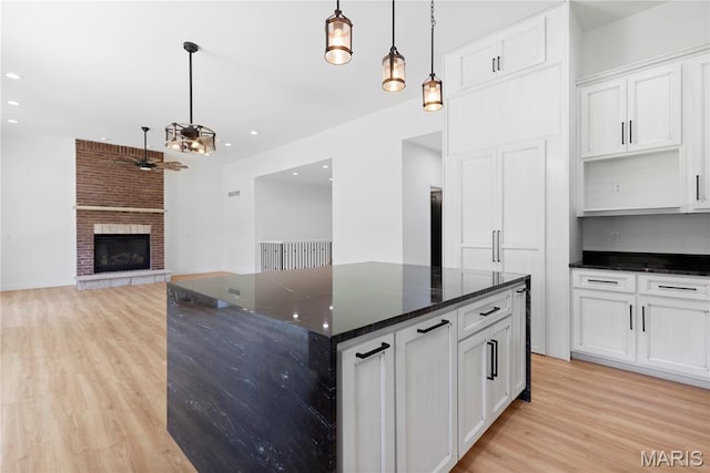 522 Dove Dr, Saint Charles, MO 63301 - kitchen featuring light wood-style floors, a center island, white cabinetry, ceiling fan, and recessed lighting