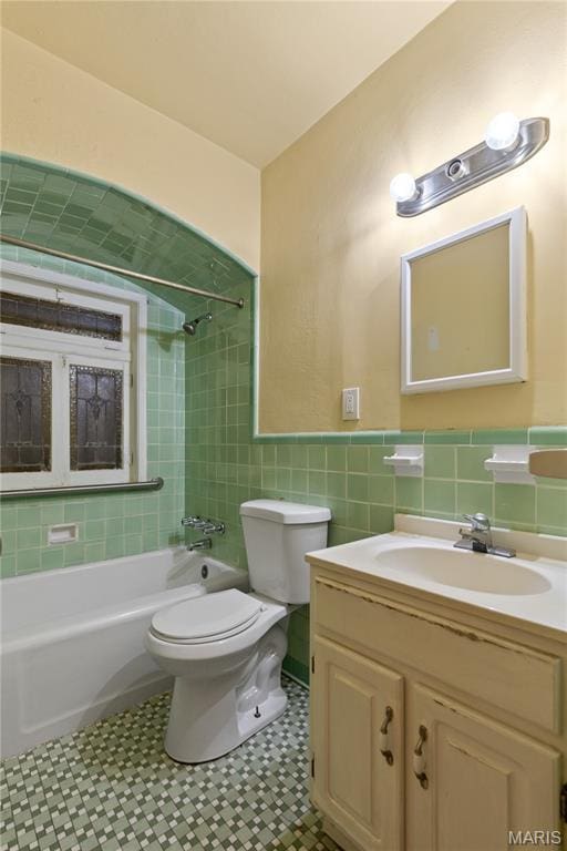 7637 Lynn Ave, University City, MO 63130 - bathroom featuring vanity, tile walls, bathtub / shower combination, tile patterned floors, and wainscoting