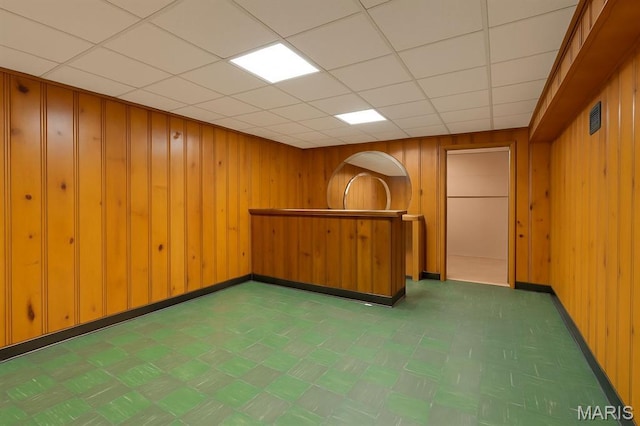 7637 Lynn Ave, University City, MO 63130 - bar featuring wood walls, tile patterned floors, and a drop ceiling