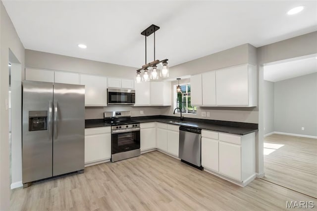 490 Lula Dr, Florissant, MO 63031 - kitchen with stainless steel appliances, light wood-style floors, dark countertops, white cabinetry, and recessed lighting