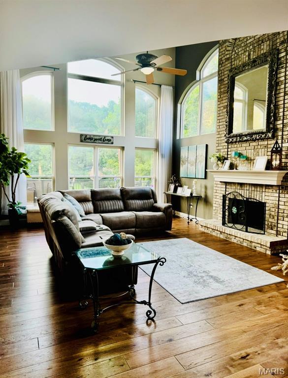 616 Remmick Stables Ct, Ofallon, MO 63368 - living room with a towering ceiling, ceiling fan, wood-type flooring, and a fireplace