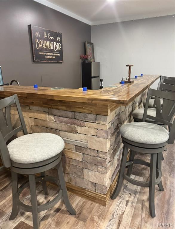 616 Remmick Stables Ct, Ofallon, MO 63368 - indoor dry bar with freestanding refrigerator, wood finished floors, and ornamental molding