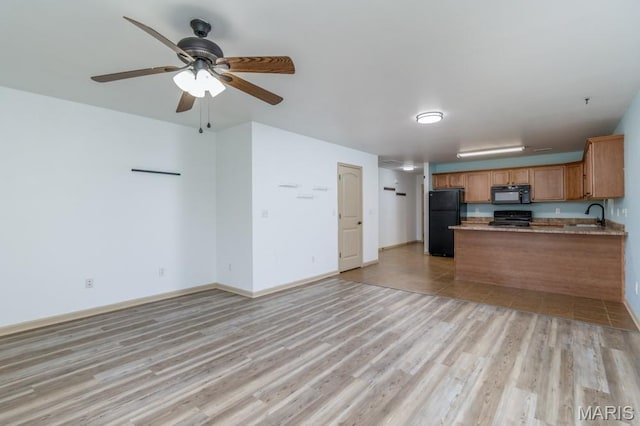 100 Edna St Unit B, Waynesville, MO 65583 - kitchen with black appliances, brown cabinets, a peninsula, and open floor plan