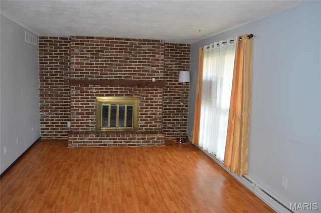 1726 Mayenne Ct, Saint Louis, MO 63125 - unfurnished living room featuring wood finished floors, a fireplace, and a textured ceiling