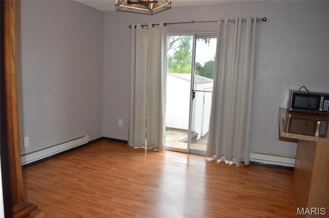 1726 Mayenne Ct, Saint Louis, MO 63125 - unfurnished dining area featuring a baseboard radiator, a baseboard heating unit, light wood-style flooring, and a chandelier