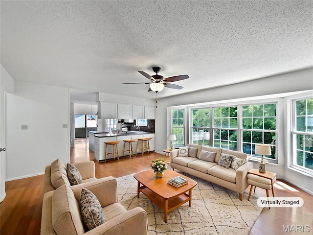 4033 Treeshadow Dr, Saint Peters, MO 63376 - living area featuring healthy amount of natural light, ceiling fan, light wood-style flooring, and a textured ceiling