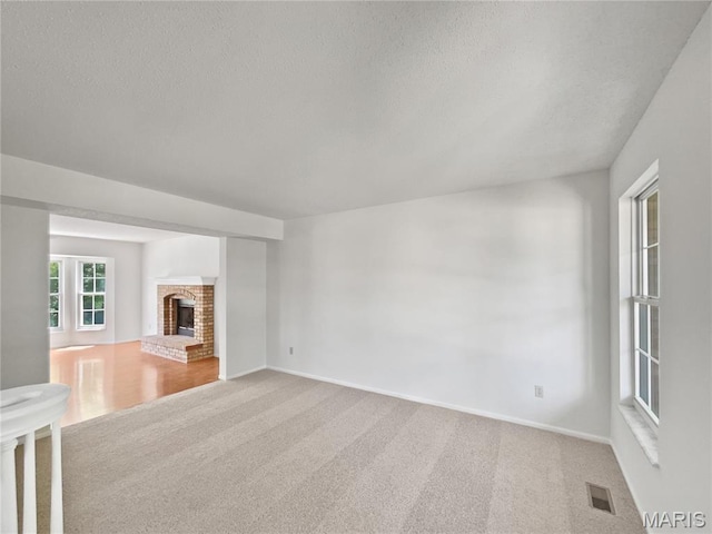 4033 Treeshadow Dr, Saint Peters, MO 63376 - unfurnished living room with carpet, a textured ceiling, and a brick fireplace