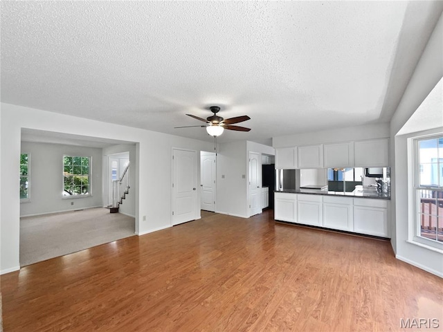 4033 Treeshadow Dr, Saint Peters, MO 63376 - unfurnished living room with stairs, wood finished floors, a textured ceiling, and ceiling fan