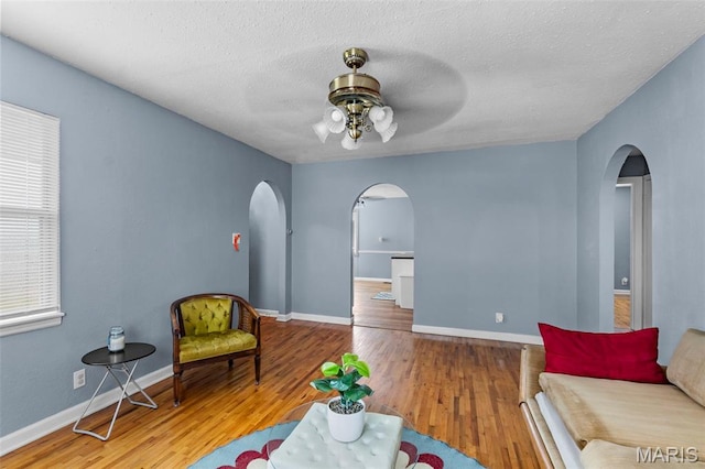 5748 State Highway 25, Cape Girardeau, MO 63701 - living area featuring arched walkways, ceiling fan, wood finished floors, and a textured ceiling
