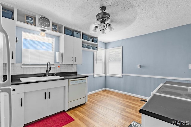 5748 State Highway 25, Cape Girardeau, MO 63701 - kitchen with white appliances, dark countertops, light wood-style floors, white cabinets, and wainscoting